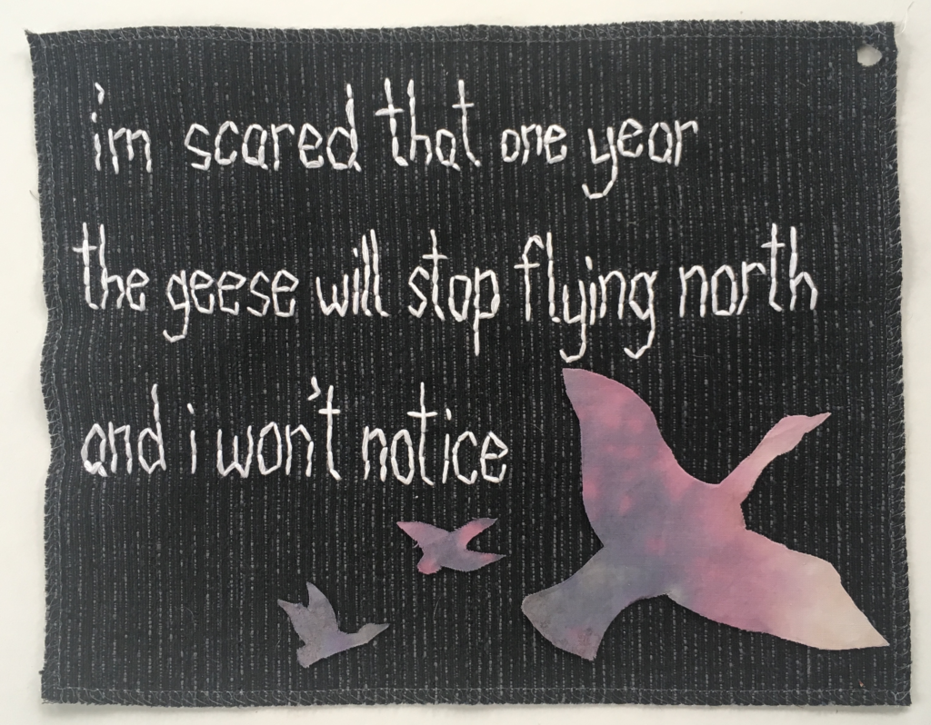 an embroidered panel with three lines of poetry above colorful dyed fabric silhouettes of three geese